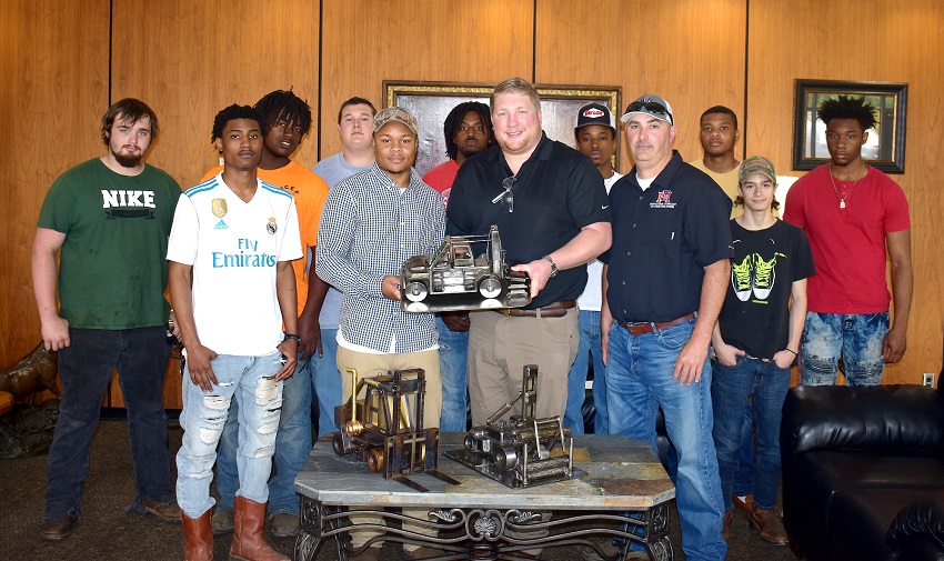 EMCC welding student Bryson Jenkins, at left center, and Davis Taylor pf Taylor Machine Works hold up a miniature sculpture of a Taylor Machine Works forklift made by Jenkins. EMCC and Jenkins are donating the sculpture that earned a first place in the Mississippi SkillsUSA Championships to Taylor Machine Works. EMCC welding student Bryson Jenkins, at left center, and Davis Taylor pf Taylor Machine Works hold up a miniature sculpture of a Taylor Machine Works forklift made by Jenkins. EMCC and Jenkins are donating the sculpture that earned a first place in the Mississippi SkillsUSA Championships to Taylor Machine Works.